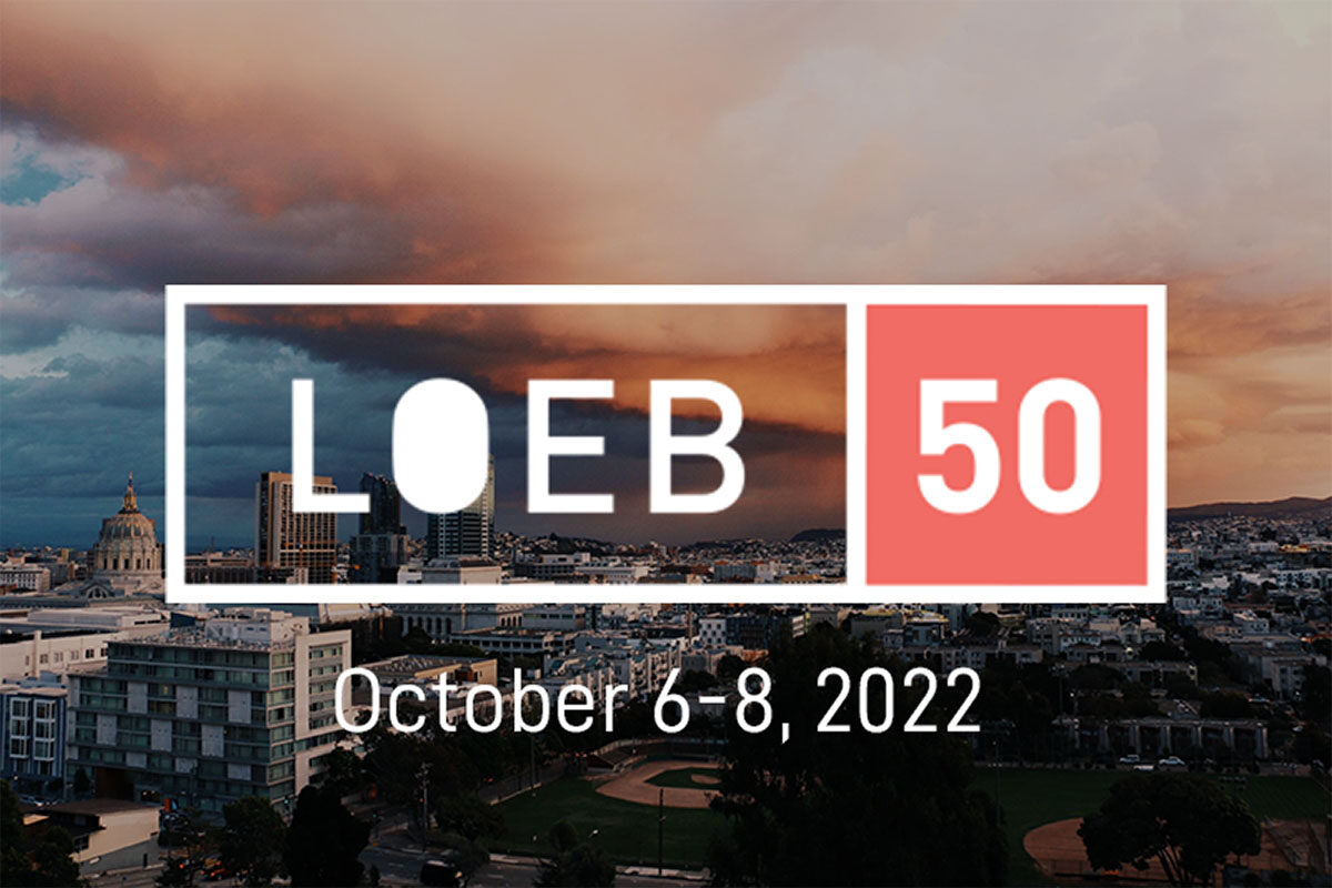 Loeb 50 logo overlaid on a cloudy sky above a city at sunset.