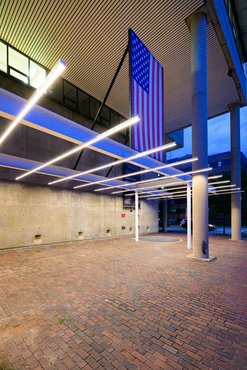 Looking up at the oavilion's American flag through an array of thin long lights.