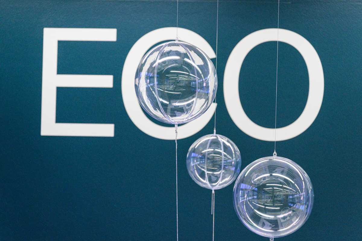 Suspended translucent globes. The top globe is shown in the middle of the letter "C" in the word eco of the exhibiits title.