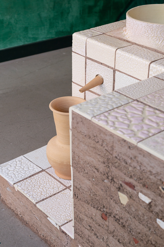 white tiled counter with step for brown terracotta pot to capture water