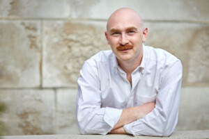 Headshot of Maximilian Mueller against stone background