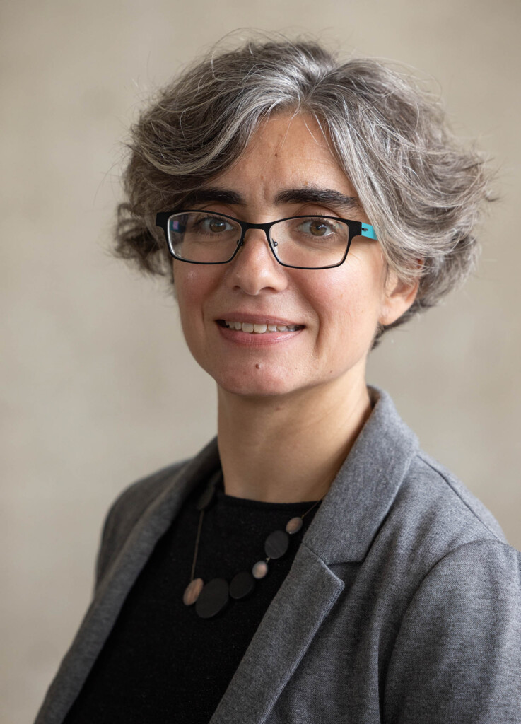 Photo of a female wearing glasses, looking at the camera and smiling