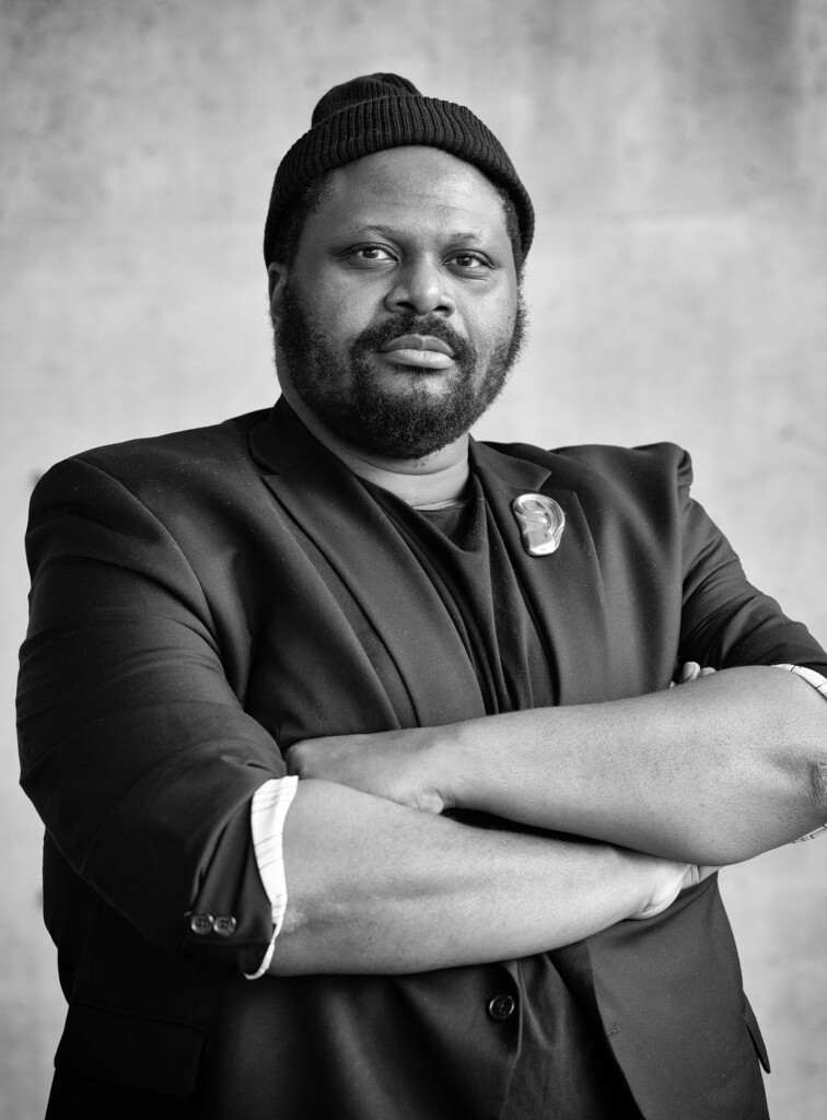 Black and white photo of African American male and looking into the camera