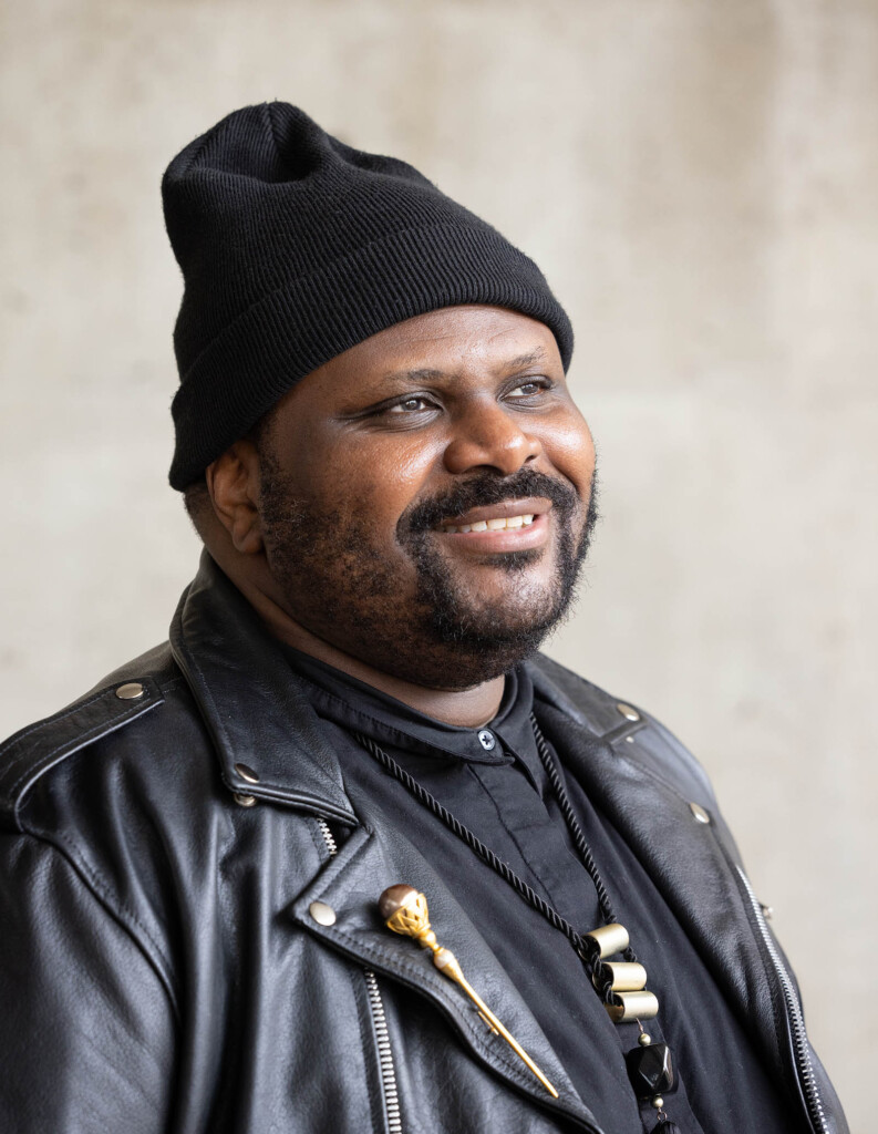 Headshot of African American male, smiling and looking away into a distance