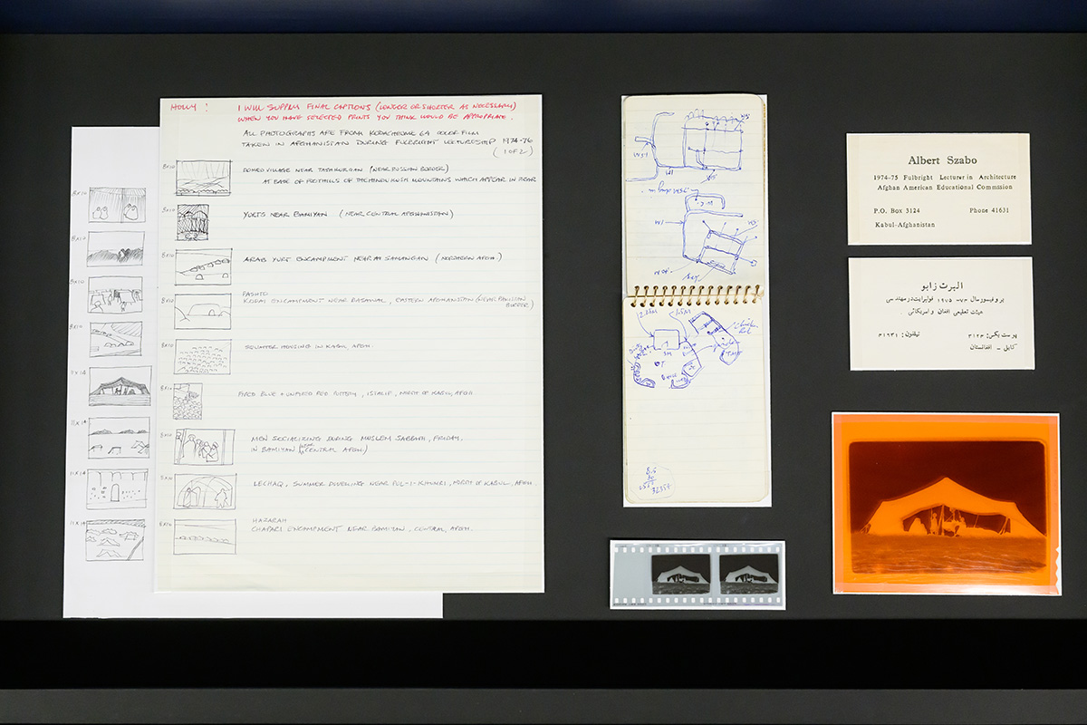 A collection of papers with handwritten notes and drawings, business cards, and photographic negatives.