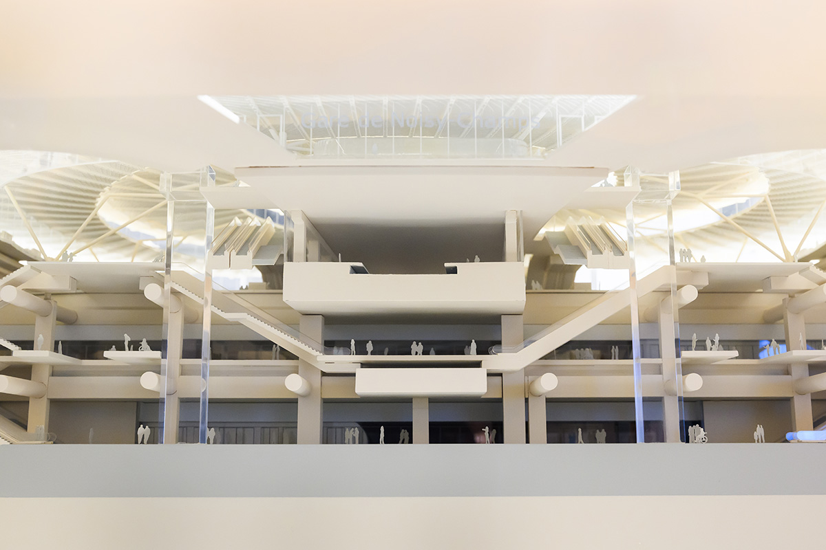 Architectural model of a subway station interior showing multiple stories with stairways below a spiral shaped roof with openings for light.