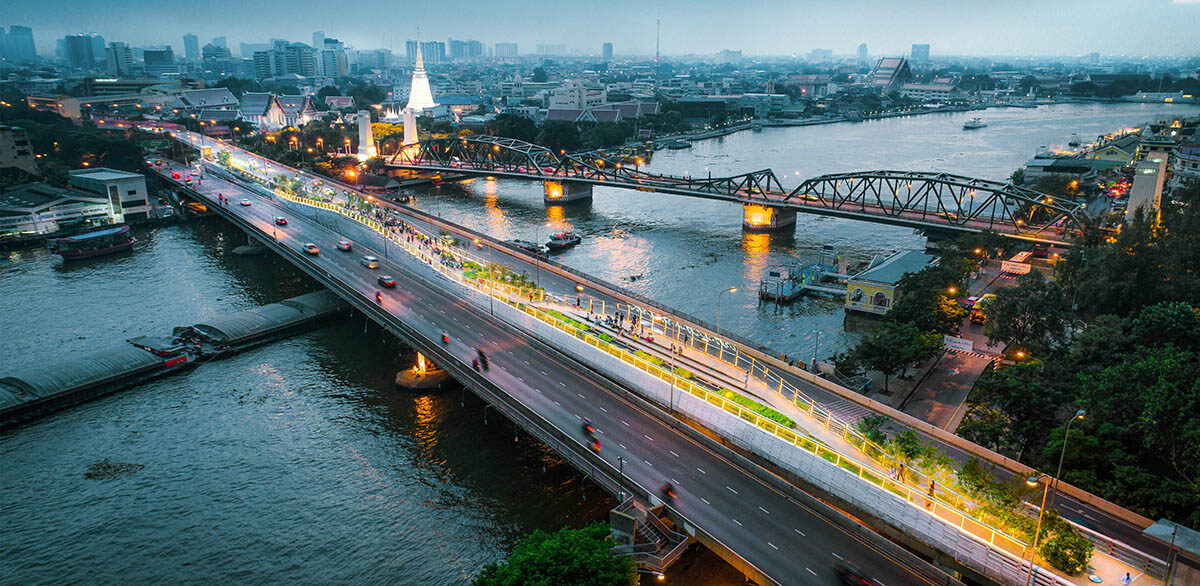 Aerial image of a bridge over a large river in the evening.