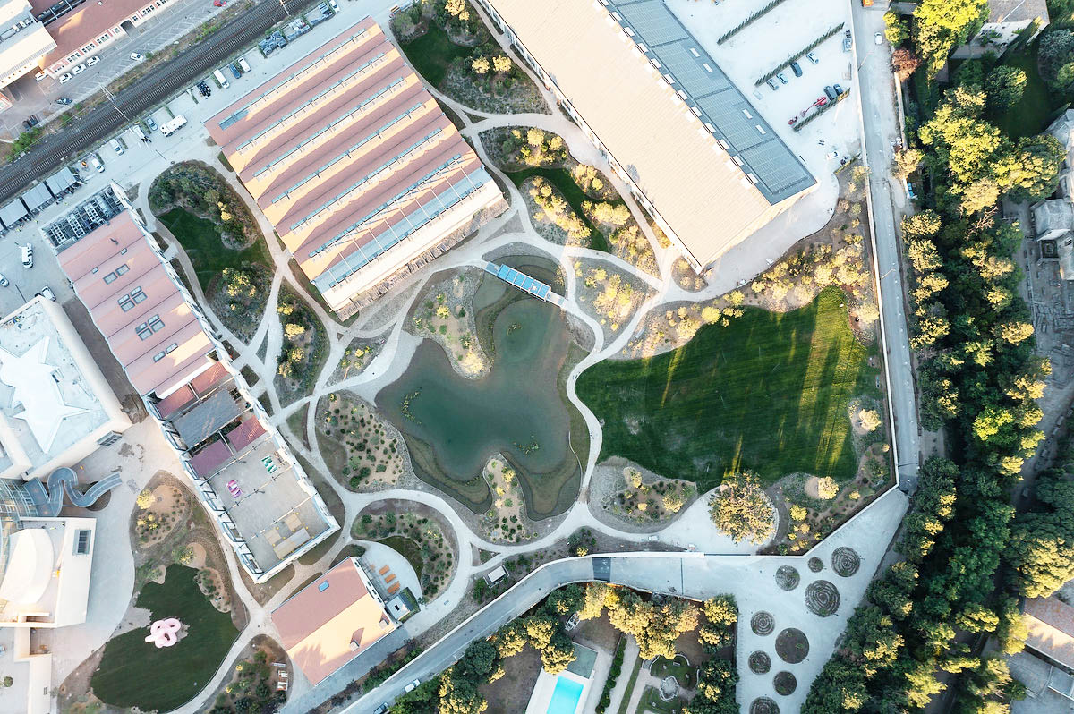 Aerial view of a few buildings and green space.