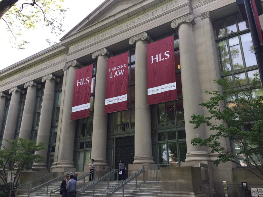 People mingle on the front steps of the Harvard Law School building.