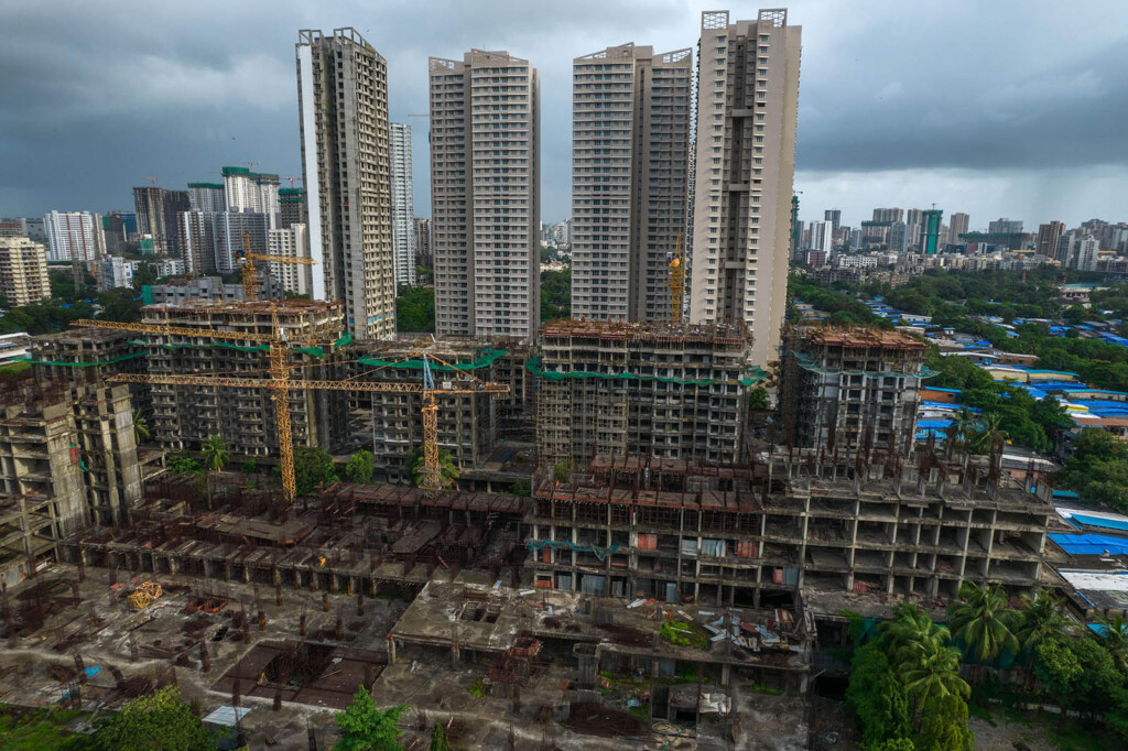 Photograph of four skyscrapers with a construction site in the foreground