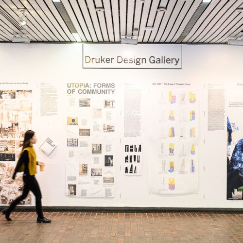 person walking in front of an exhibition of various materials in tall panels