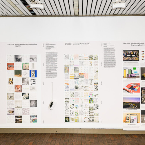 a person walking in front of exhibition of various materials in tall panels