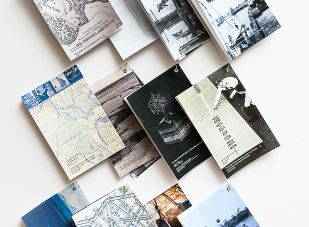 Display of pamphlets, layered and hanging on small hooks.