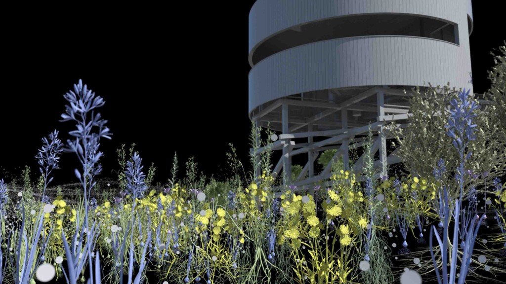 A tower in a field of flowers at night
