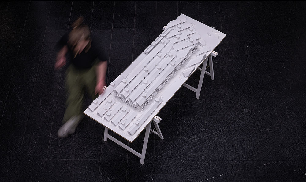 A photograph taken from a high angle showing an architectural model sitting on saw horses.