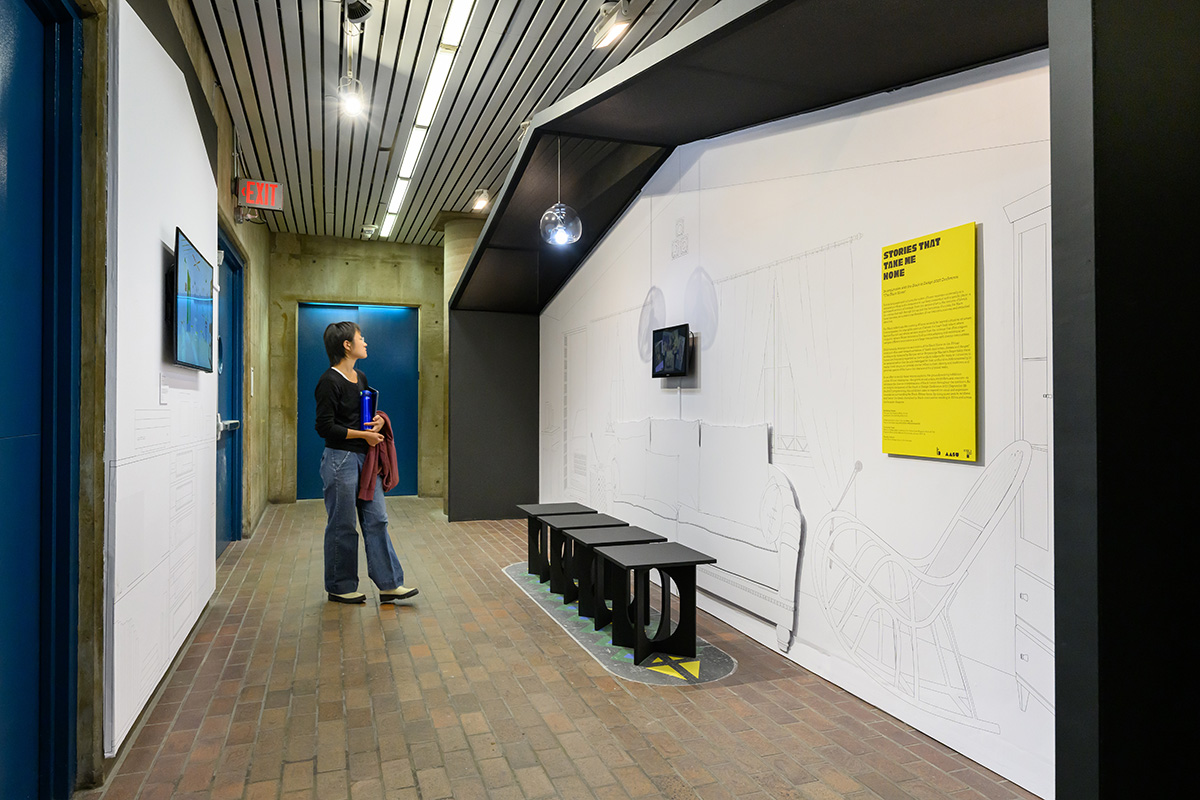 A person views the exhibit in Gund hall.