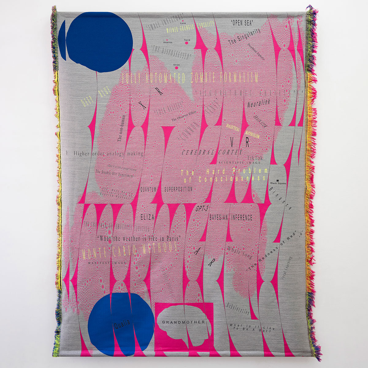 fabric tapestry with pink and blue shapes on a gray backround and words in different typefaces and colors.