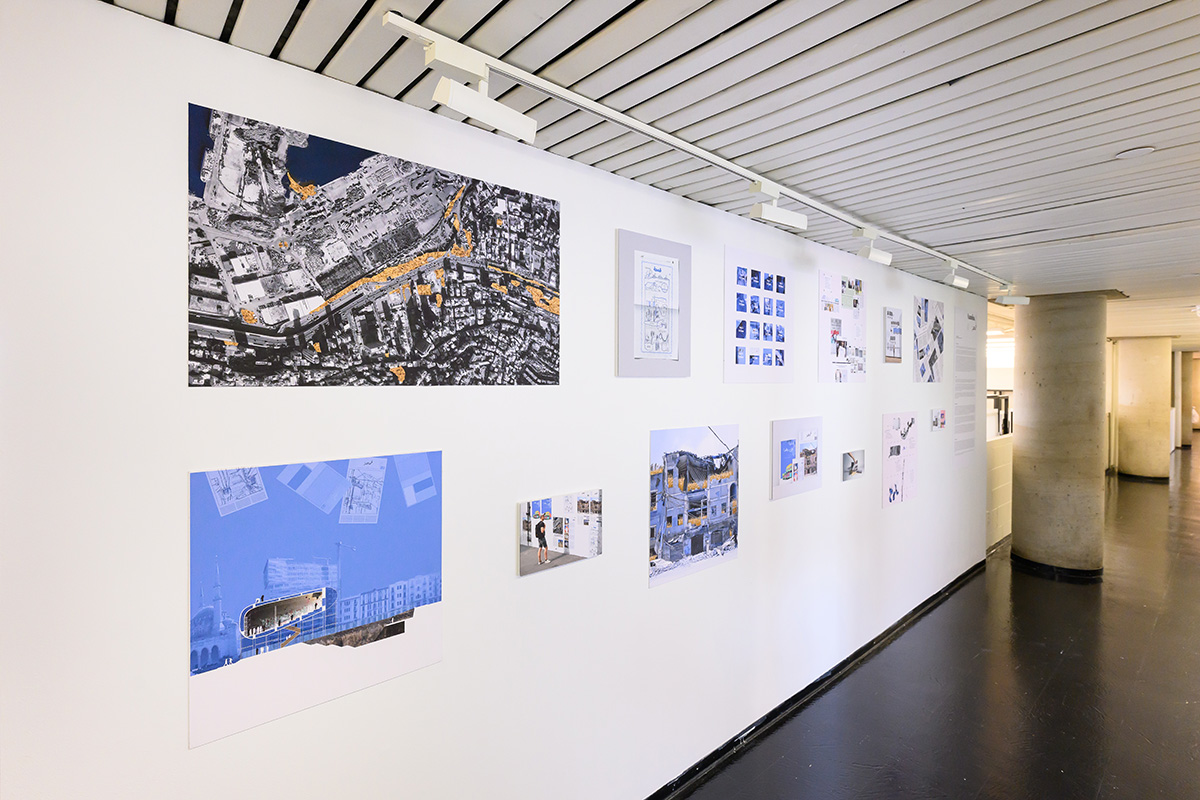 A view of a corridor in Gund Hall showing a display of images on a white wall.