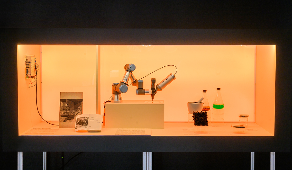 A colorful lit case displaying books, a robotic arm, and a variety of scientific lab equipment.
