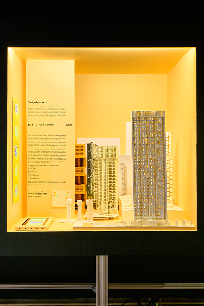 A brightly lit case displaying a variety of architectural models of high-rise buildings.