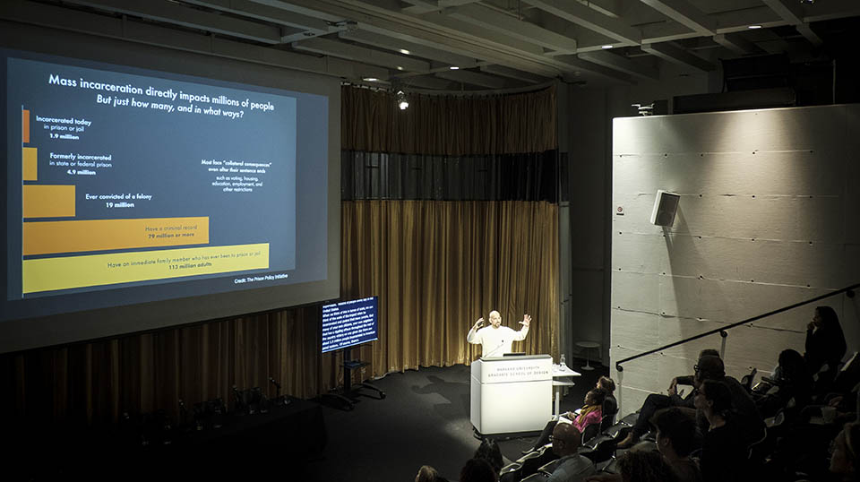 Andrew Manuel Crespo speaks at a podium at Carceral Landscapes and shows a slide titled "Mass Incarceration directly impacts millions of people"