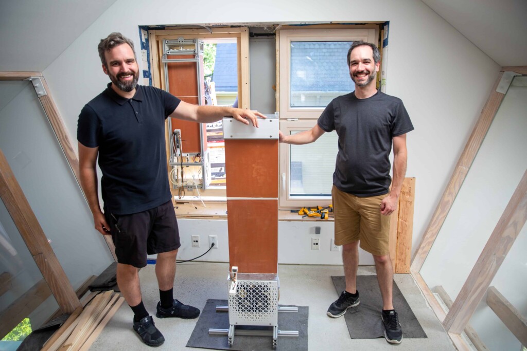 Jonathan Grinham and Jack Alvarenga, two of the team leads, with an evaporative cooling unit as it was installed at HouseZero. Credit: Wyss Institute at Harvard University