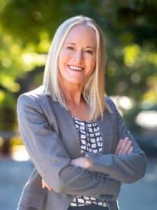 Outdoor Headshot of Mayor Kate Colin in front of a tree canopy.