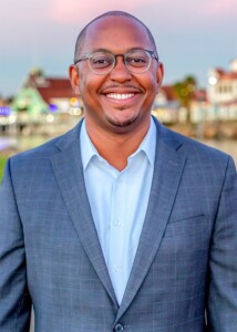 Headshot of Mayor Rex Richardson against an urban landscape.