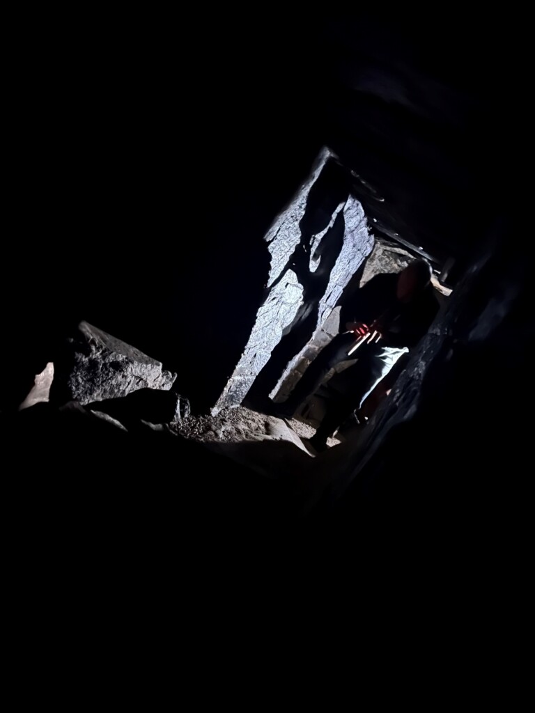 Image of boulder structure with light and shadow against a jet black background