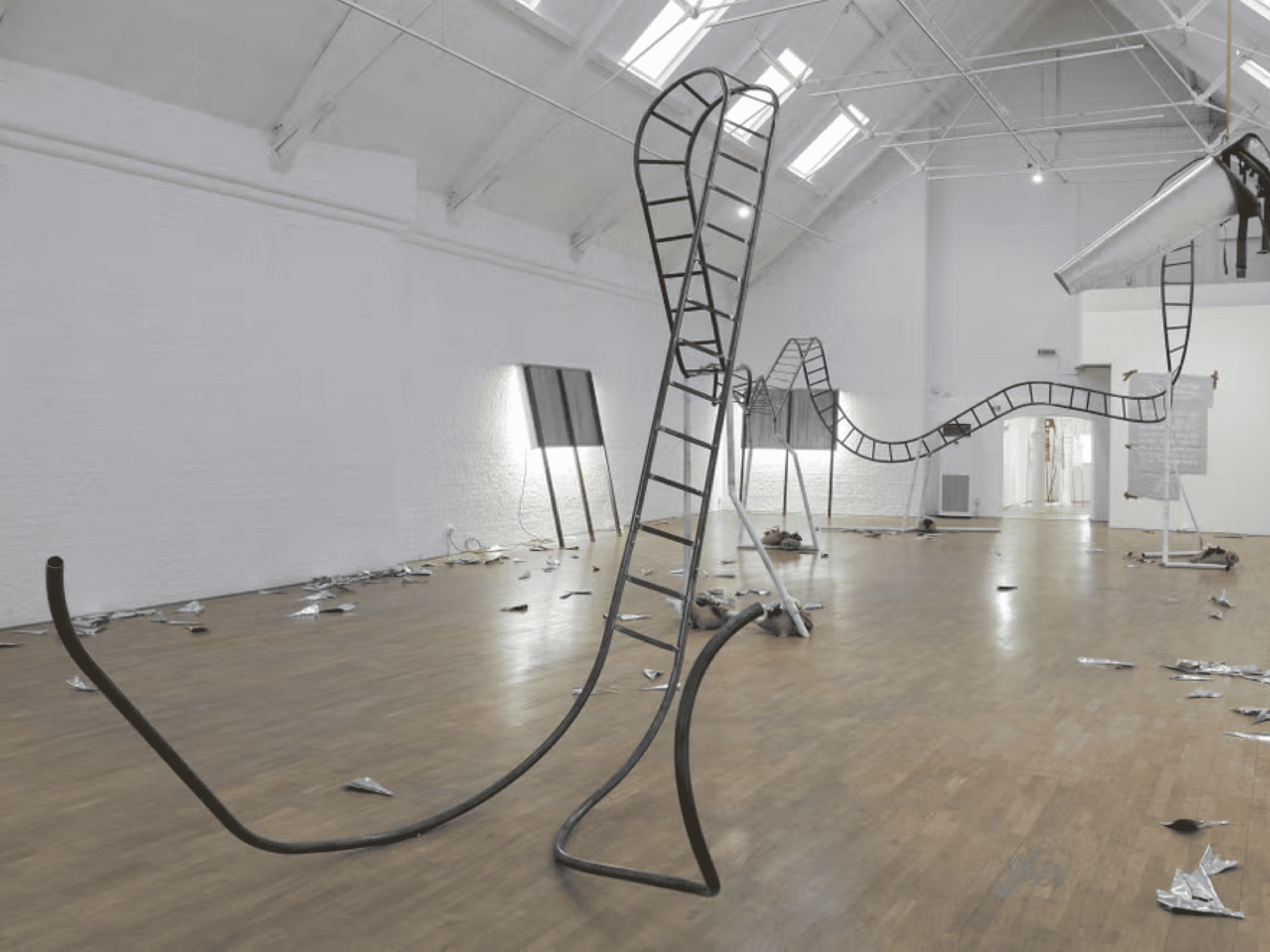 Freestanding twisting metal stair in a white sunlit room.