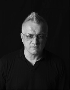 Black and white headshot of Timothy Archambault against a black backdrop. 