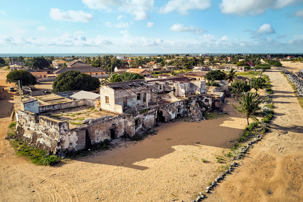 Aerial view of building ruins with a road in from of it and a blue sky