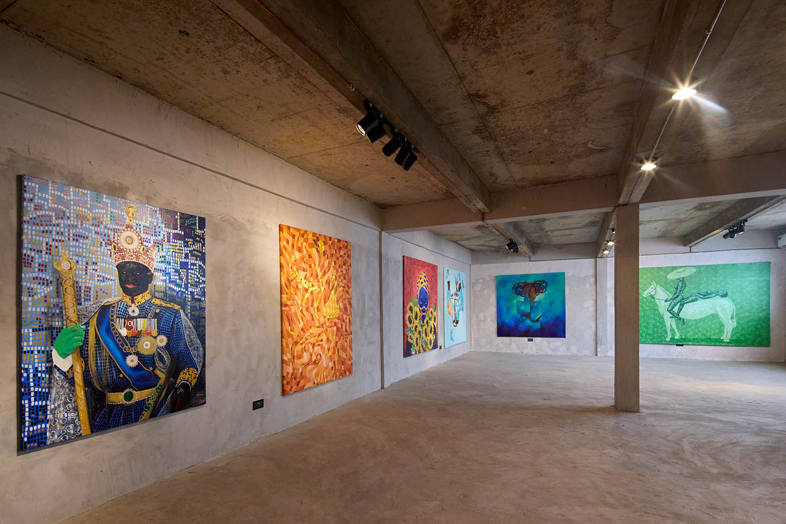 A photo pf a gallery space with six colorful paintings hanging on the walls.
