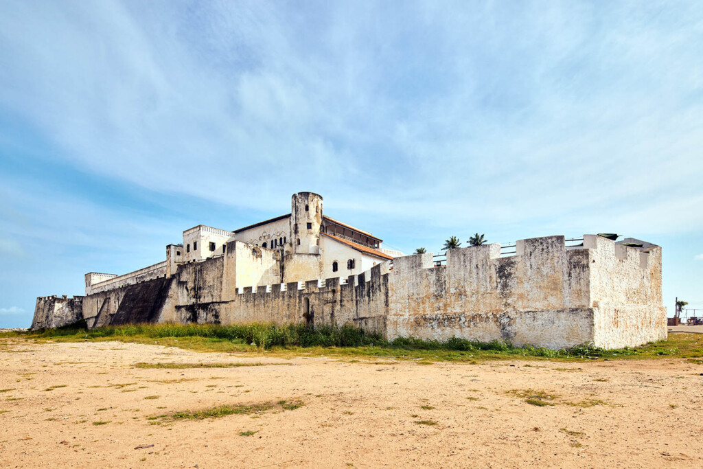 A photo of a white washed fort with sandy foreground