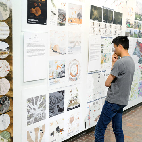A person viewing images on the wall in Druker Design Gallery.