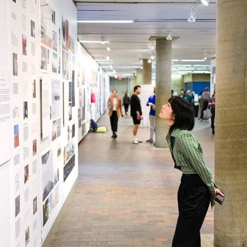 A person viewing images on the wall in Druker Design Gallery.