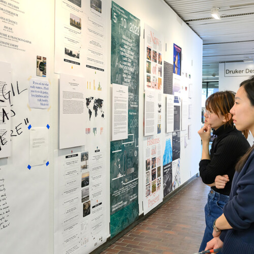 People viewing images on the wall in Druker Design Gallery.