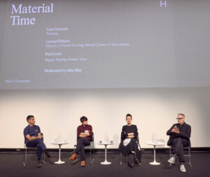 Four people sit on chairs in the theater of the Harvard Graduate School of Design. One man on the right of the image holds a microphone.