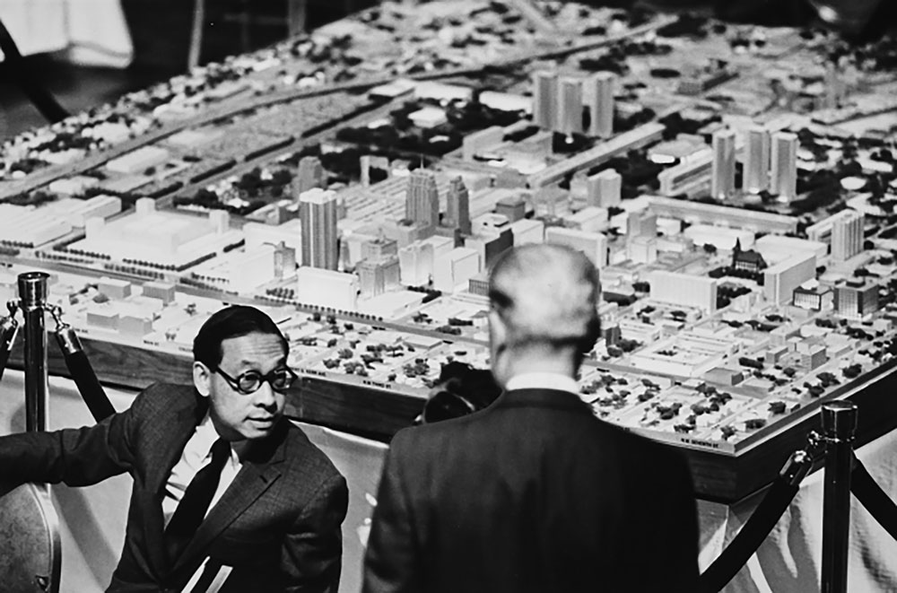 A photograph of I.M. Pei standing in front of a large model of an urban area.