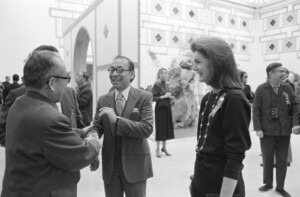 A photograph of architect I.M. Pei standing with Jacqueline Kennedy Onassis and other guests in the lobby of the Fragrant Hills Hotel.