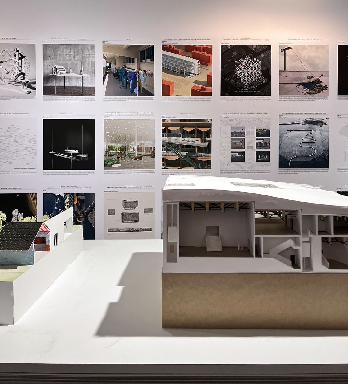 Two architectural models infront of an array of square images