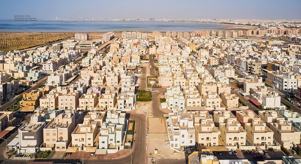 A spread from a book showing a dense residential neighborhood in a middle eastern country with many 3-4 story houses clustered together.