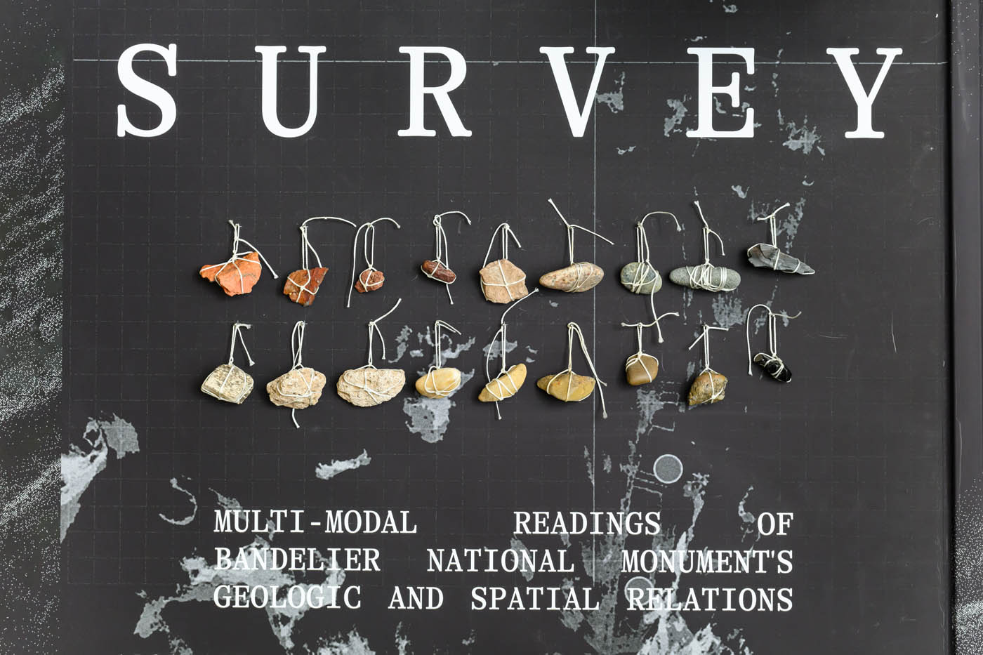 Title of the exhibit, with hanging rocks on on strings
