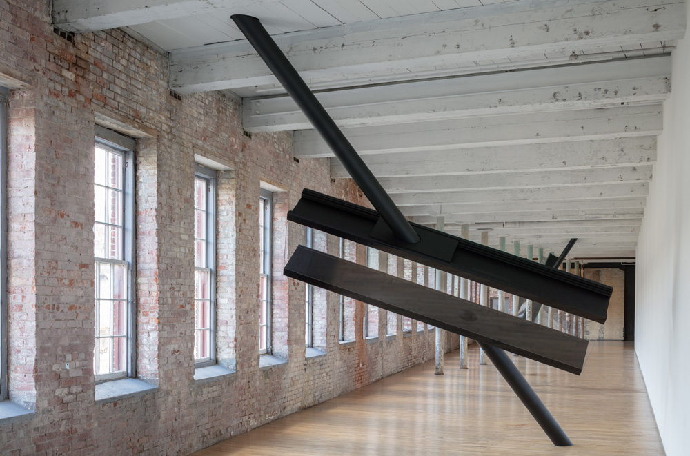An installation of an artwork by Sarah Oppenheimer showing a black metal structure in a long gallery.