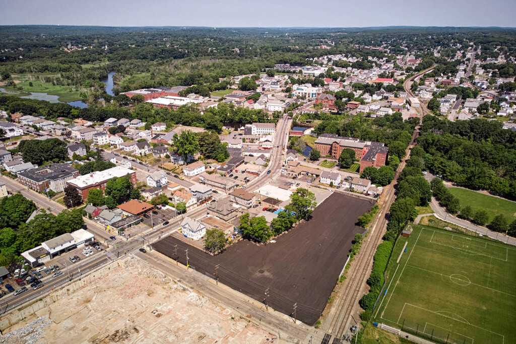 Aerial image of an empty asphalted lot surrounded by houses