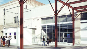 A color photograph of the Geffen Contemporary at MOCA in Los Angeles showing a portico made of red steel beams. Visitors purchase tickets and walk outside the structure.