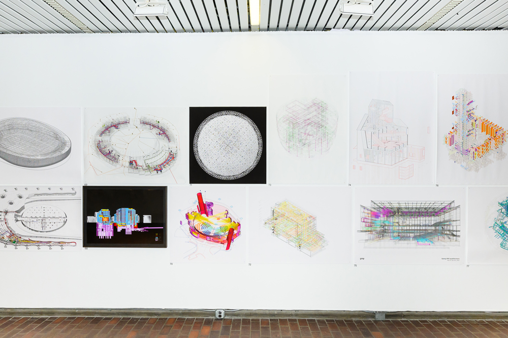 An installation shot of the exhibition Architecture as an Instruction-based art showing a group of large, complex architectural drawings hanging on a white wall.
