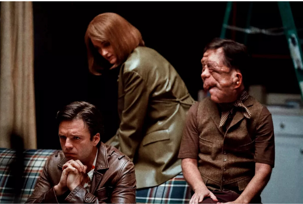 A film still from "A Different Man" showing three people sitting on a plaid couch.