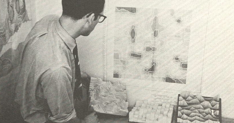 man looking at maps and models