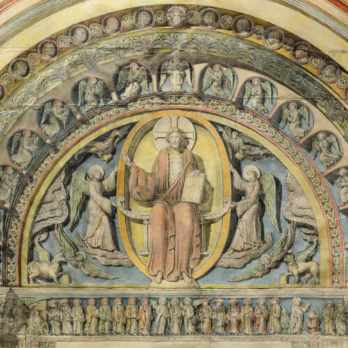 A detail of painting of a sculpture, in the arch above a church door.